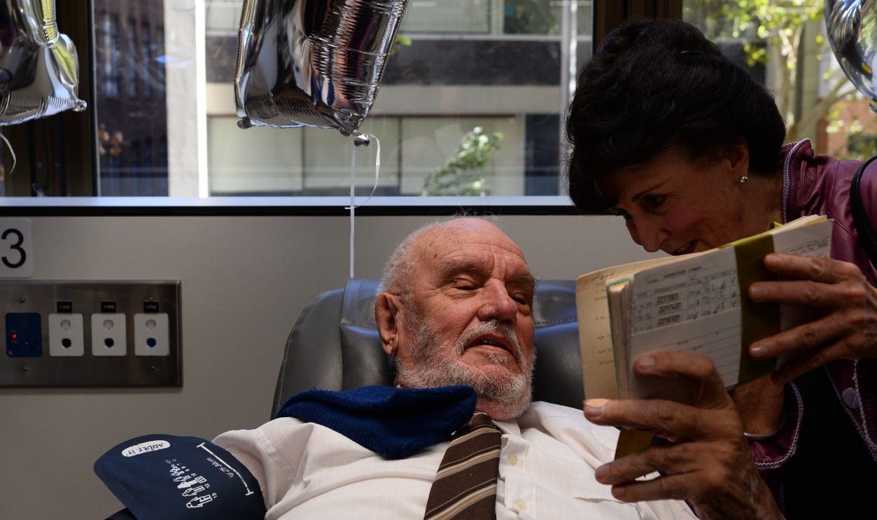 11 May 2018, Australia, Sydney: Robin Barlow, the former director of the blood donor service of the Australian Red Cross shows James Harrison the documents of his first blood donation. 63 years after his first blood donation, Harris gave his last donation. 1173 is the total number of donations of blood plasma the 81-year-old has made. 