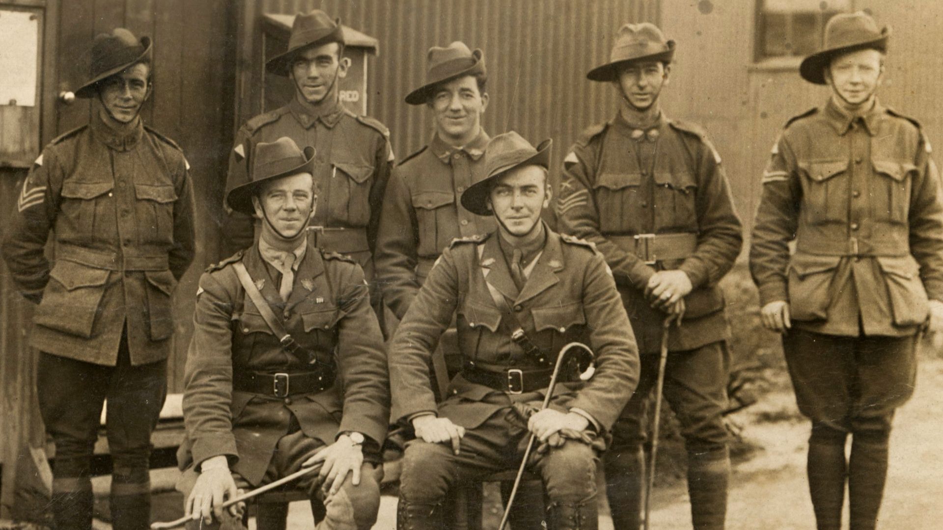 grayscale photo of men holding walk cane
