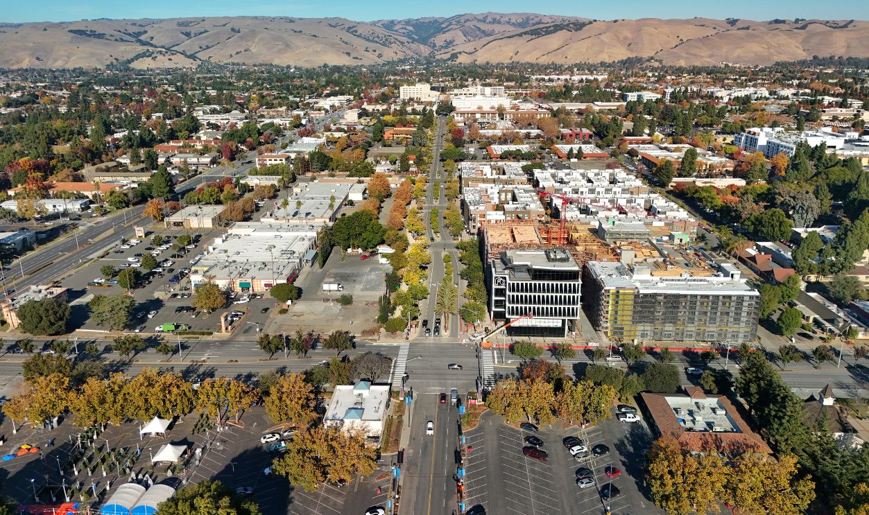 Aerial view of central Fremont during Autumn, featuring new housing construction and beautiful trees, with Capitol Avenue in the center and the Diablo Range in the background.