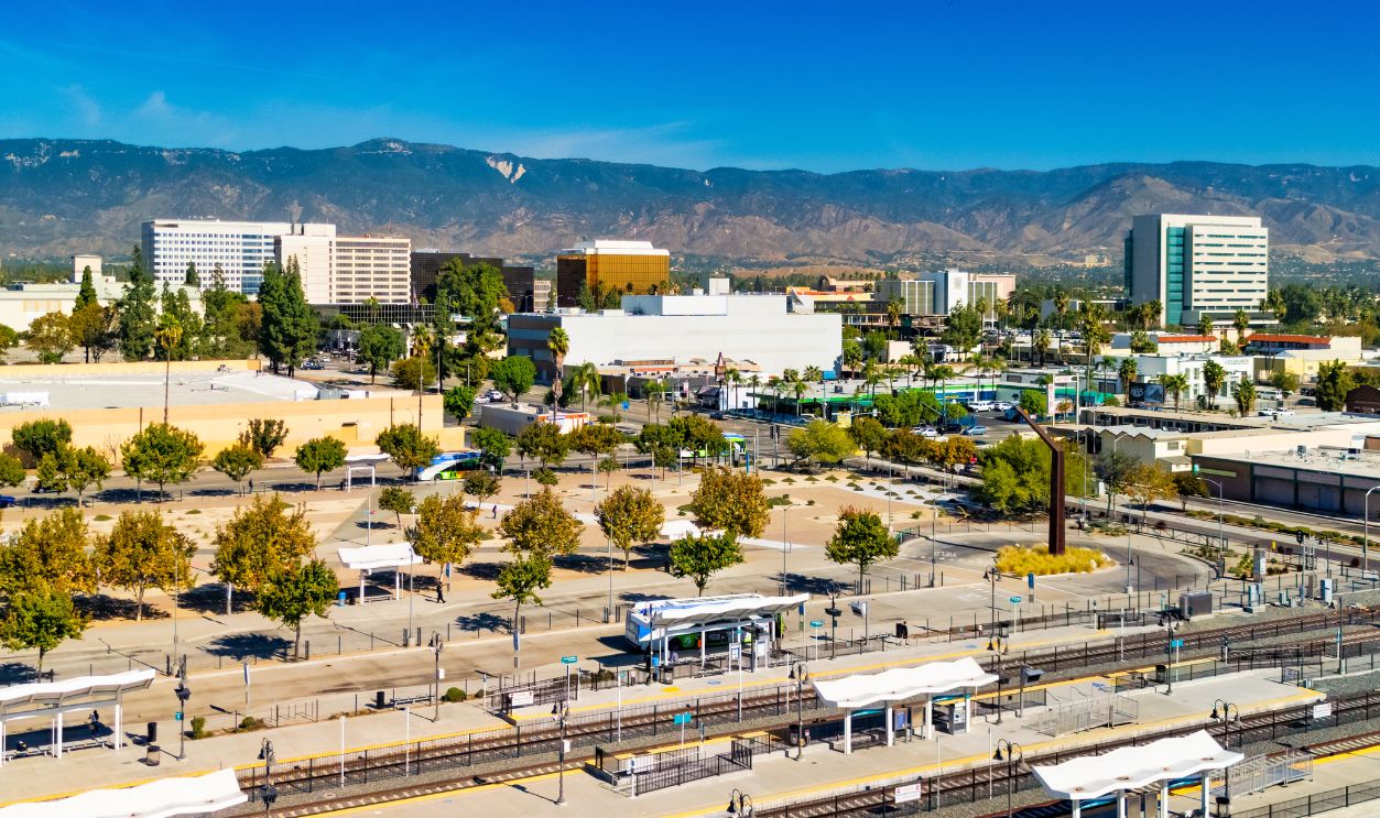 Skyline view of Downtown San Bernardino with the San Bernardino Mountain Range in the background and a train station in the foreground. San Bernardino is part of the Inland Empire area of Southern California.