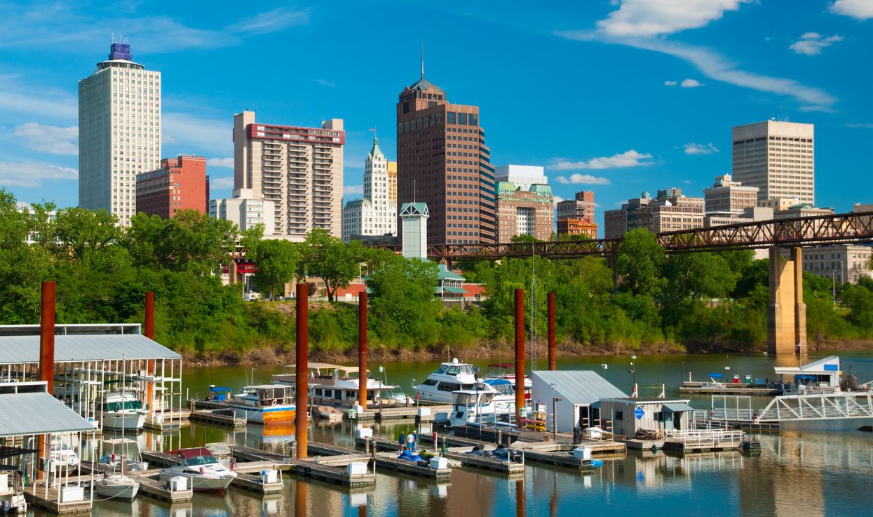 Memphis downtown skyline w/ trees and Wolf Rover and boats and harbor in the foreground.