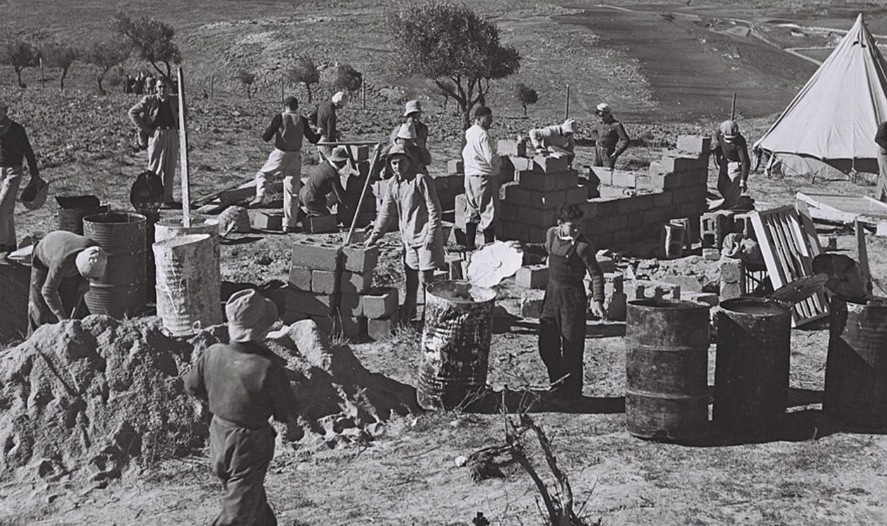 SETTLERS BUILDING THE FIRST HOUSE