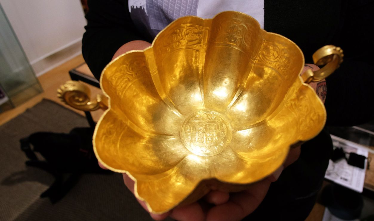 An employee shows a Spanish gold chalice at the Guernsey's in New York on July 6, 2015. An exquisite gold chalice, an emerald-encrusted crucifix and a gold bar go on auction in New York next month, recovered from a Spanish ship that sank off the coast of Florida in 1622. The extraordinary items were discovered by a US treasure hunter from the wreckage of the Nuestra Senora de Atocha, the most famous vessel in a Spanish flotilla that sank after sailing into a hurricane. The ship, laden with New World riches, was one of at least eight that sank in the storm en route back to Spain. She went down with 265 people on board, of whom only five survived