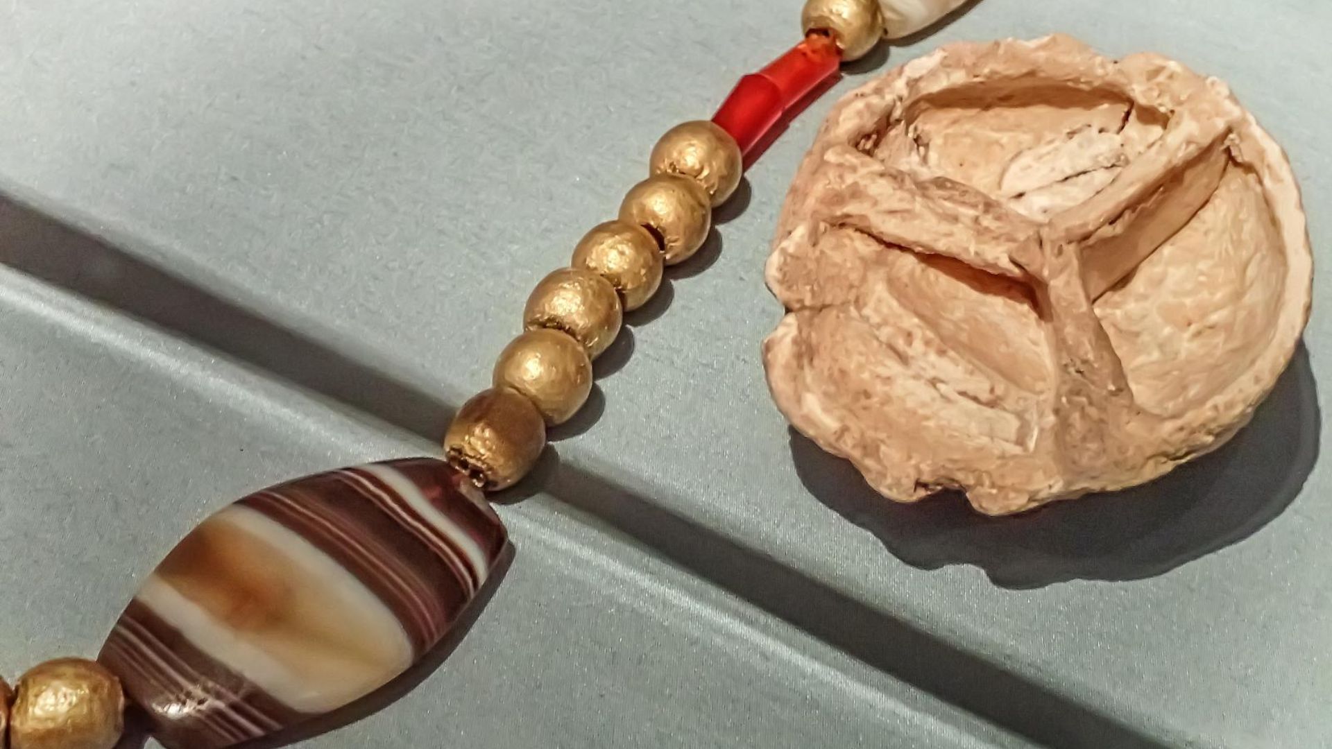 File:Necklace of agate, gold and carnelian beads with cosmetics palette recovered from the royal cemetery of Ur, Iraq 2550-2450 BCE.jpg