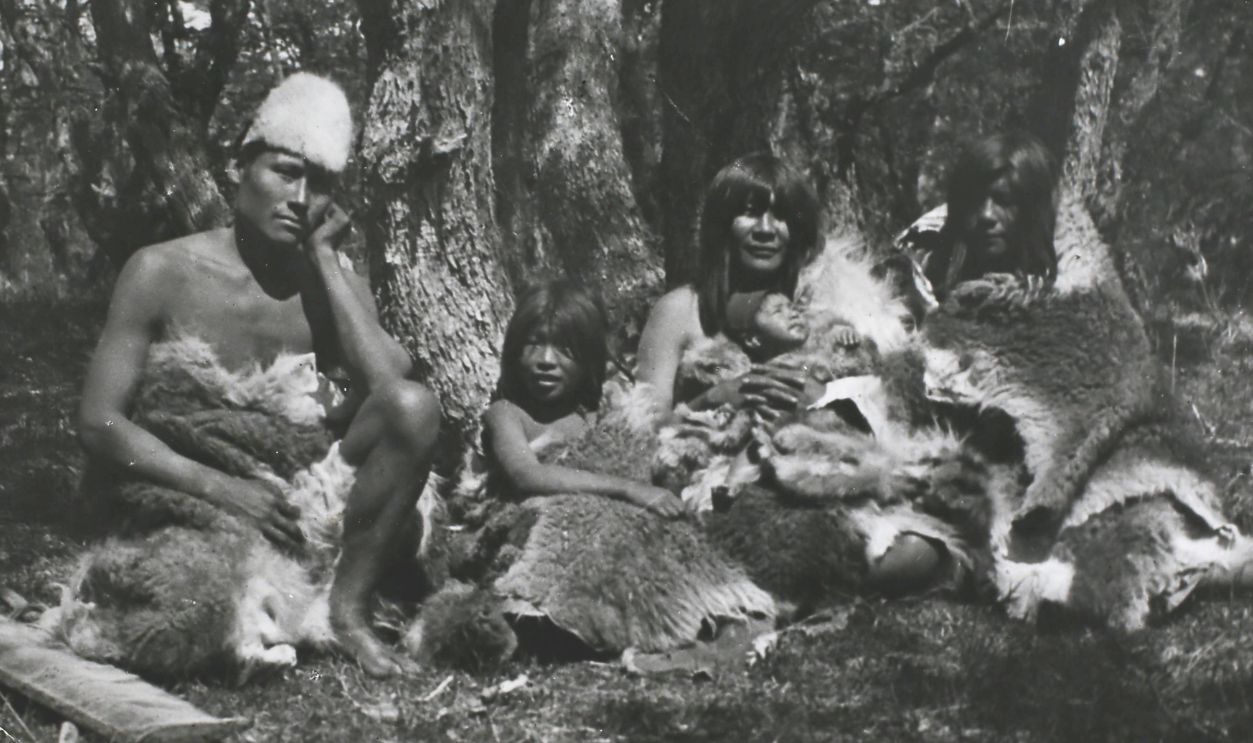 People of the Ona or Selk'nam tribe, an indigenous people who once occupied the interior of Terra del Fuego in South America, wearing their habitual costume of furs, circa 1890-1900. They subsisted by hunting and were expert archers. Their chief food was the flesh of the Guanaco, a wild camel related to the llama. In addition they ate birds, fish, shellfish, berries and fungi. Their dress was a large robe of guanaco fur, moccasins, a petticoat for the women and a fur diadem for the men. They rarely used houses and habitually slept behind a windbreak of hides. 