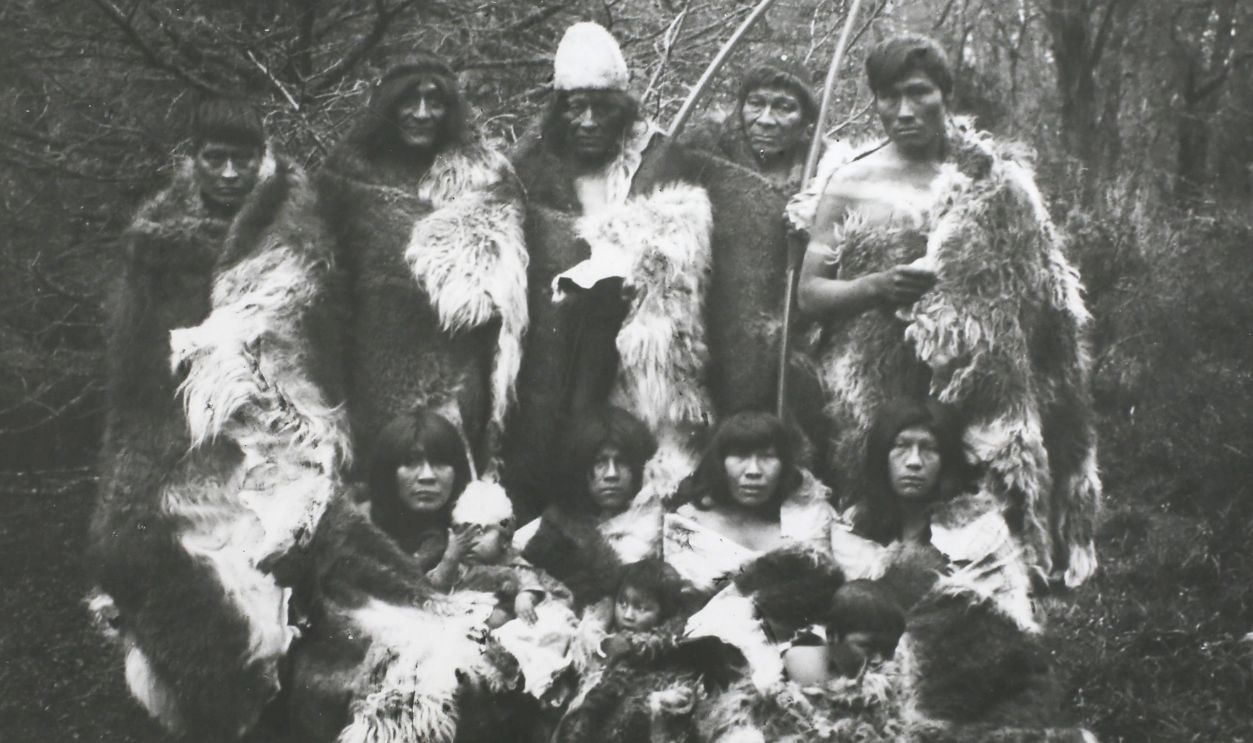 People of the Ona or Selk'nam tribe, an indigenous people who once occupied the interior of Terra del Fuego in South America, wearing their habitual costume of furs, circa 1890-1900. They subsisted by hunting and were expert archers. Their chief food was the flesh of the Guanaco, a wild camel related to the llama. In addition they ate birds, fish, shellfish, berries and fungi. Their dress was a large robe of guanaco fur, moccasins, a petticoat for the women and a fur diadem for the men. They rarely used houses and habitually slept behind a windbreak of hides.
