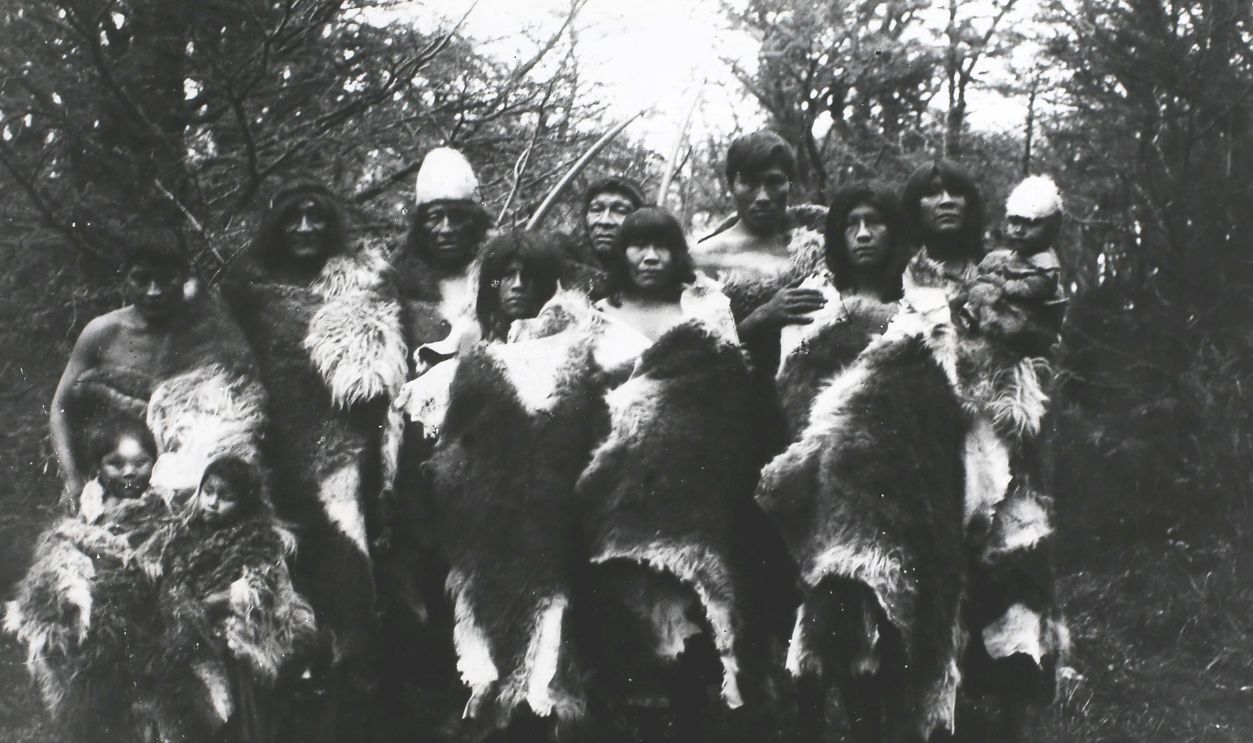 People of the Ona or Selk'nam tribe, an indigenous people who once occupied the interior of Terra del Fuego in South America, wearing their habitual costume of furs, circa 1890-1900. They subsisted by hunting and were expert archers. Their chief food was the flesh of the Guanaco, a wild camel related to the llama. In addition they ate birds, fish, shellfish, berries and fungi. Their dress was a large robe of guanaco fur, moccasins, a petticoat for the women and a fur diadem for the men. They rarely used houses and habitually slept behind a windbreak of hides. 