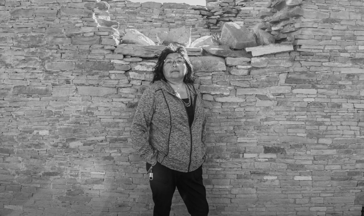 A scientist stand Pueblo Bonito wall