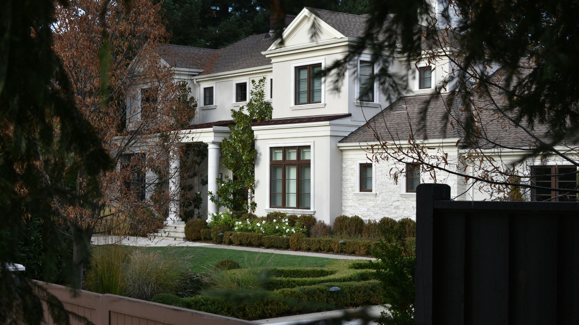 a large white house with a garden in front of it