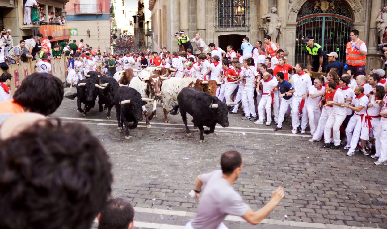 Unidentified men run from bulls in street Estafeta during San Fermin festival in Pamplona.