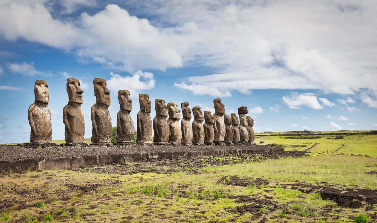 Easter Island Ahu Tongariki Panorama. Fifteen ancient civilization polynesian Moai Statues standing side by side in a row along the pacific ocean coast under sunny blue summer sky with fluffy cloudscape. Rapa Nui. Easter Island, Isla de Pascua, Polynesia, Chile, Oceania
