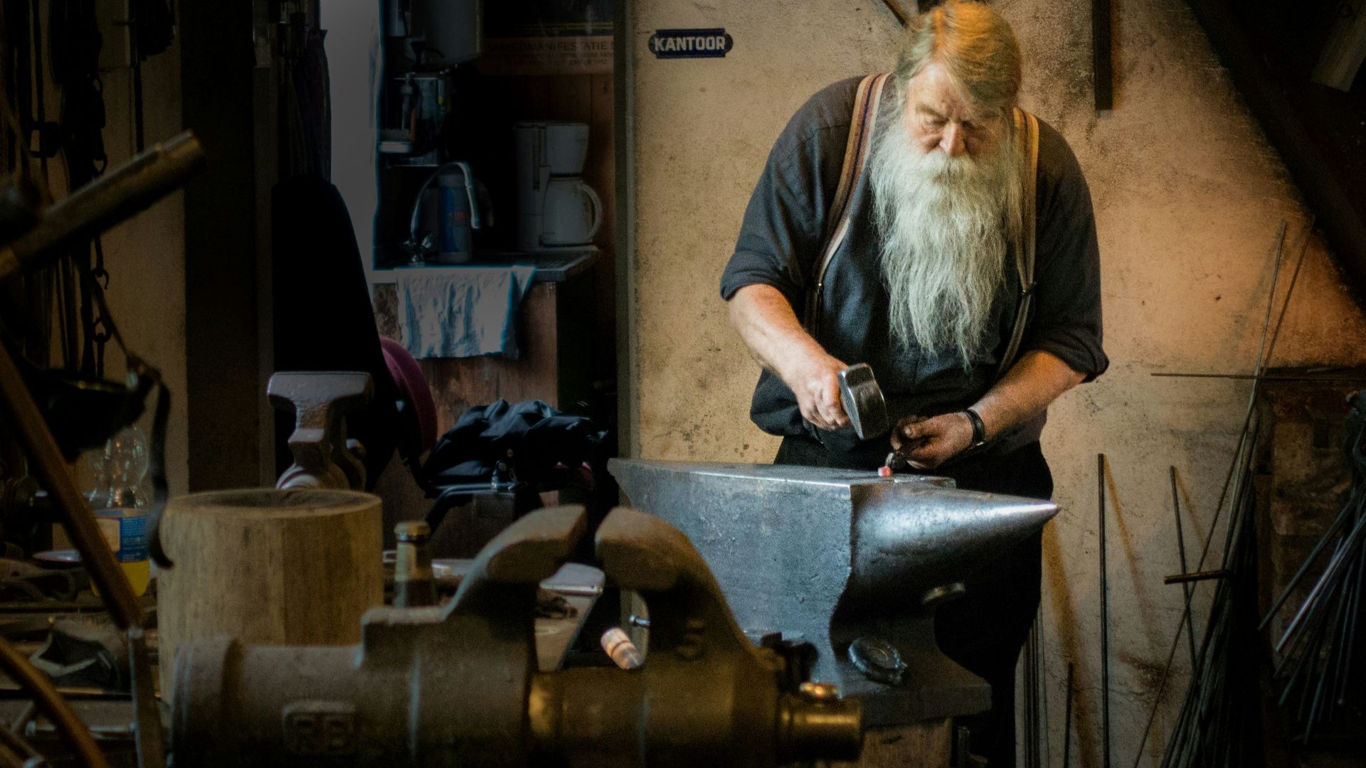 blacksmith holding mallet in garage