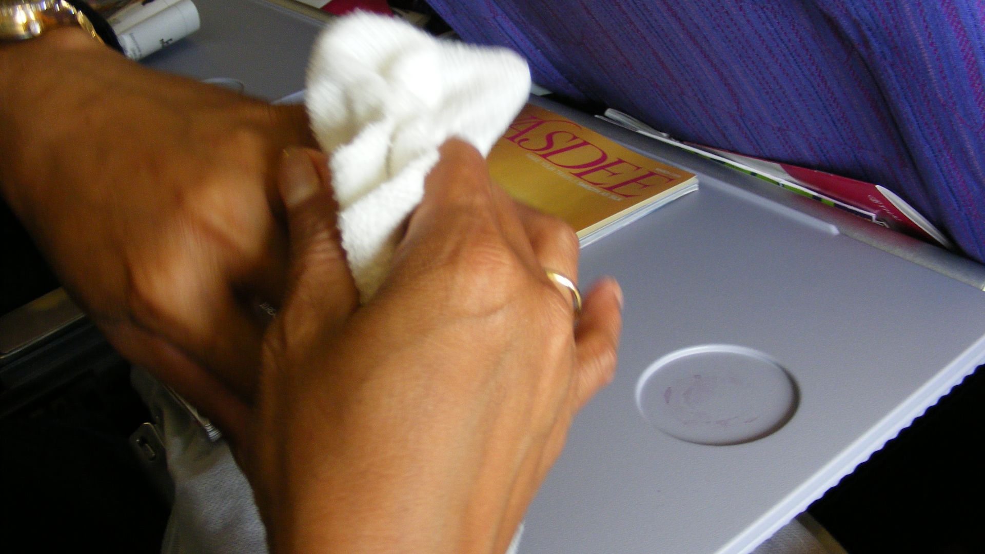 File:Aircraft passenger cleaning hands with a small steamy towel during air travel.JPG