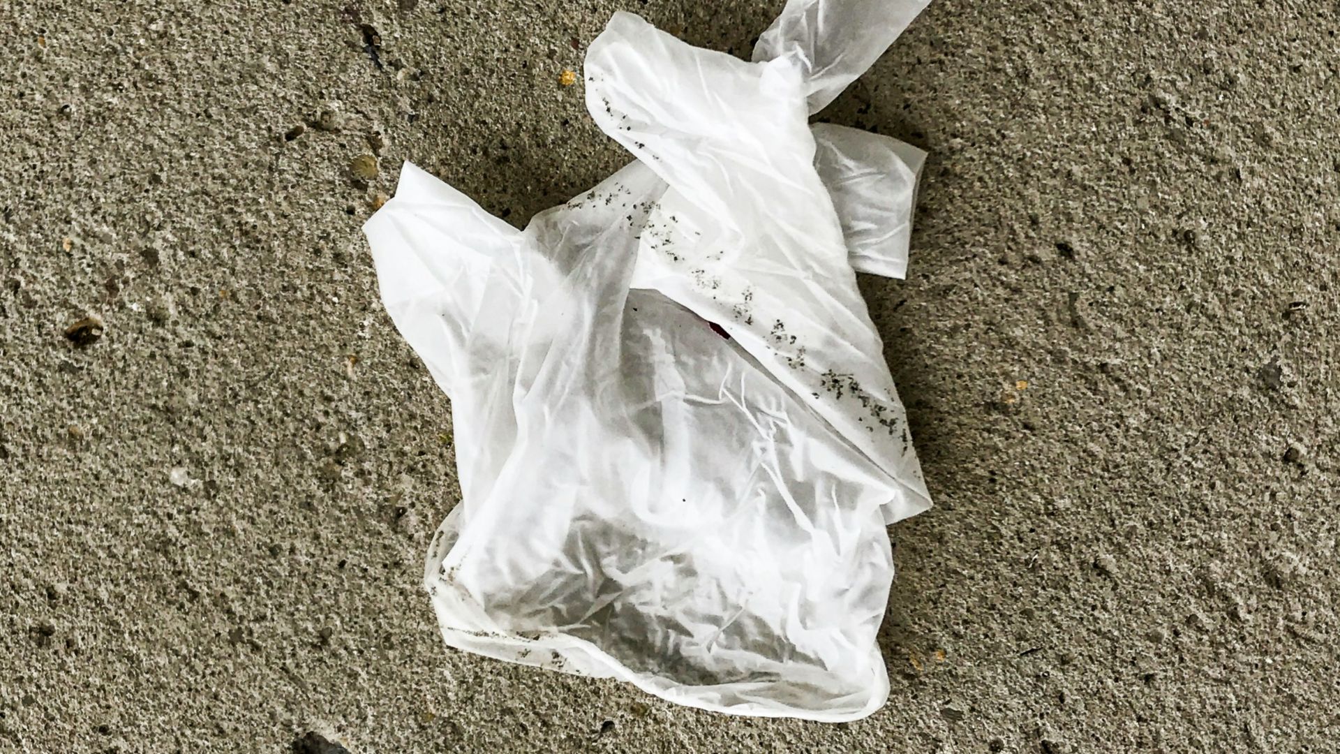 white plastic bag on brown sand