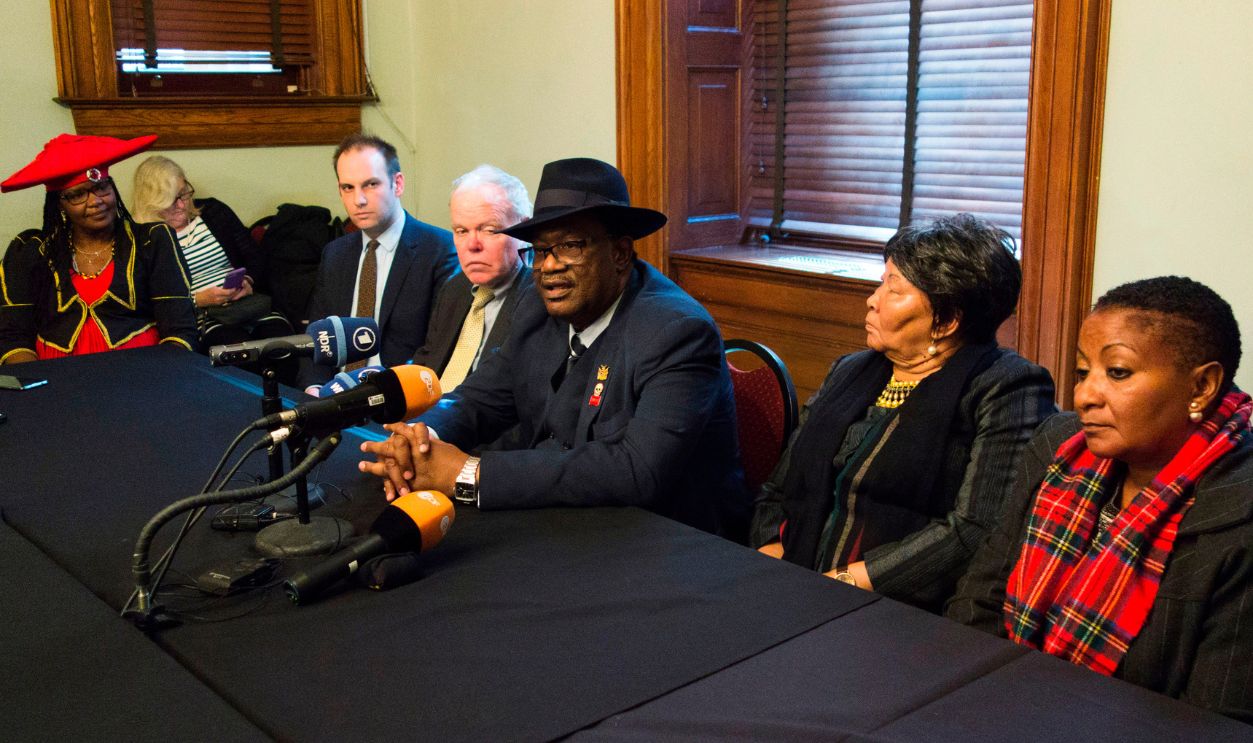 Herero chief Vekuii Rukoro (C) speaks during a news conference while other members of the delegation listen on March 16, 2017 in New York. More than a century after a long-hushed genocide took place in Namibia while under German colonial rule, descendants of the victims are getting their day in court in New York for the first time Thursday. In one of the darkest chapters of African colonial history, tens of thousands of Herero and Nama people were killed from 1904 to 1908. The two countries have been in talks for the past two years about a joint declaration on the massacres