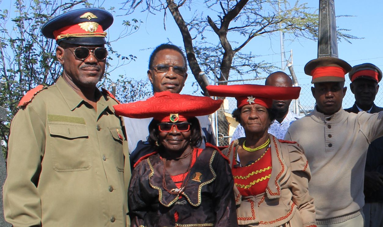 04 June 2019, Namibia, Okahandja: Members of the Namibian ethnic group of the Herero stand in the Namibian city of Okahandja at the grave of a deceased chief, partly in traditional tribal costume. 
