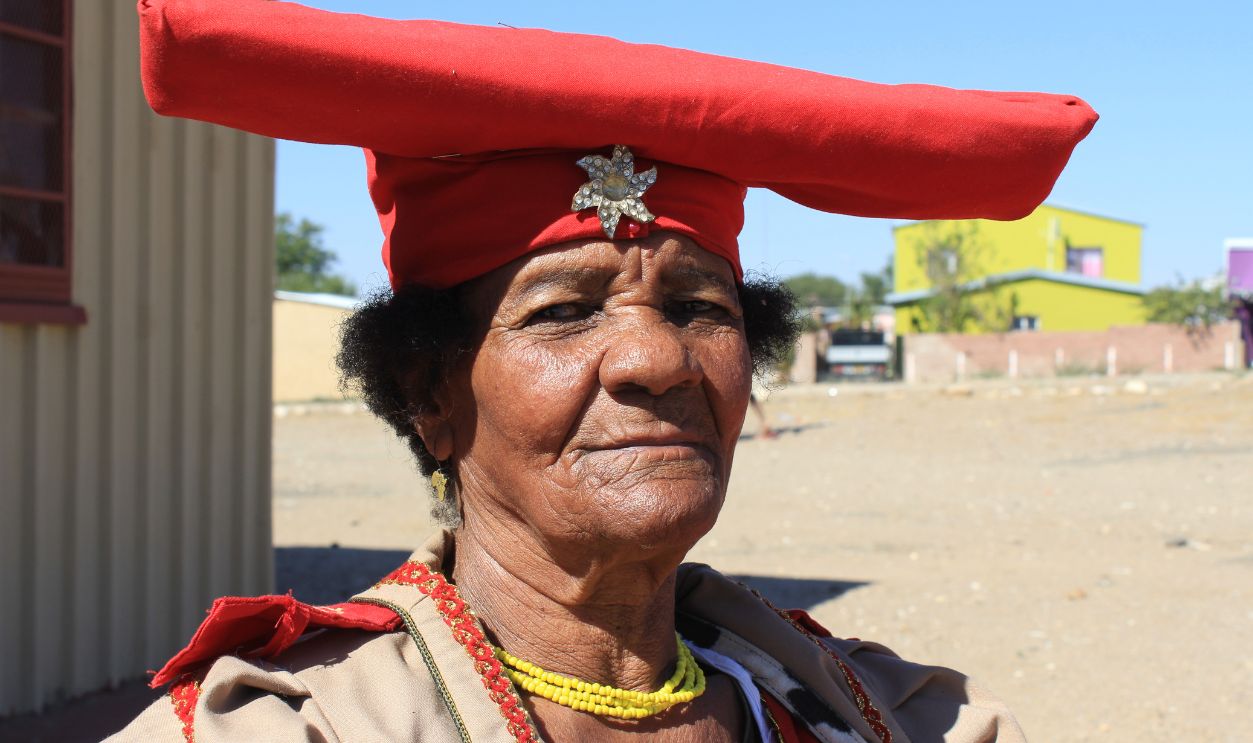 04 June 2019, Namibia, Okahandja: The Herero woman Veronika Uazapi Kandambo (75) wears the Victorian costume of her tribe. Her skin colour is slightly lighter than usual in Namibia because her grandmother was pregnant by a German farmer during the German colonial period. Photo: 4.6.19, taken in the city Okahandja, north of Namibia's capital Windhoek. 