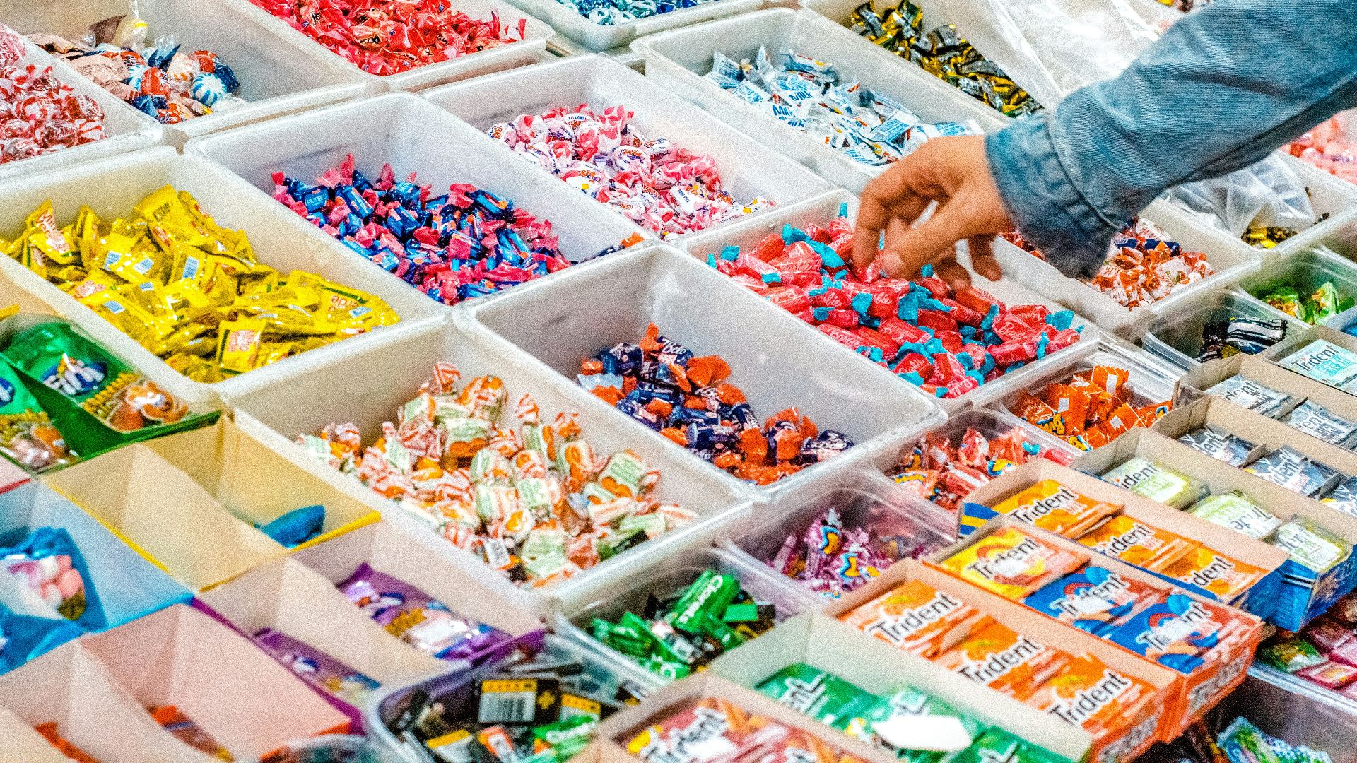 person holding a candy pack on white plastic box