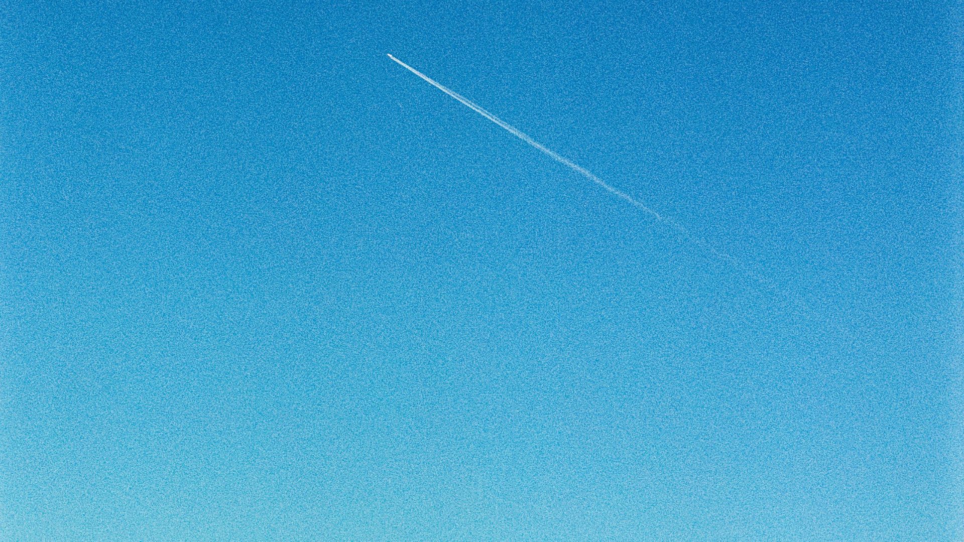 a clear blue sky with a plane in the distance