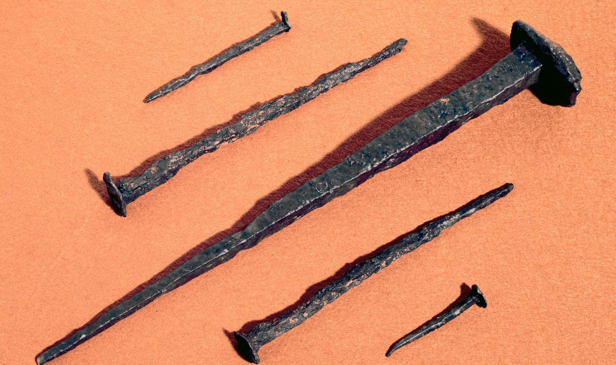 Five nails from the Roman Legionary fortress at Inchtuthill, near Dunkeld, Perthshire, Scotland. The Roman camp at Inchtuthill was constructed by Agricola in c 84 AD. During recent excavations, a hoard of over 875,000 iron nails was found at the unfinished Legionary fort. Upon abandoning the fort, the Romans secretly buried this store of valuable heavy iron nails in a pit. This was to prevent their discovery by the Caledonians, who could potentially have used the iron to make into weapons. The nails would have been made by the legion's blacksmith and larger examples were used to hold the wooden stockade around the fort in place. 