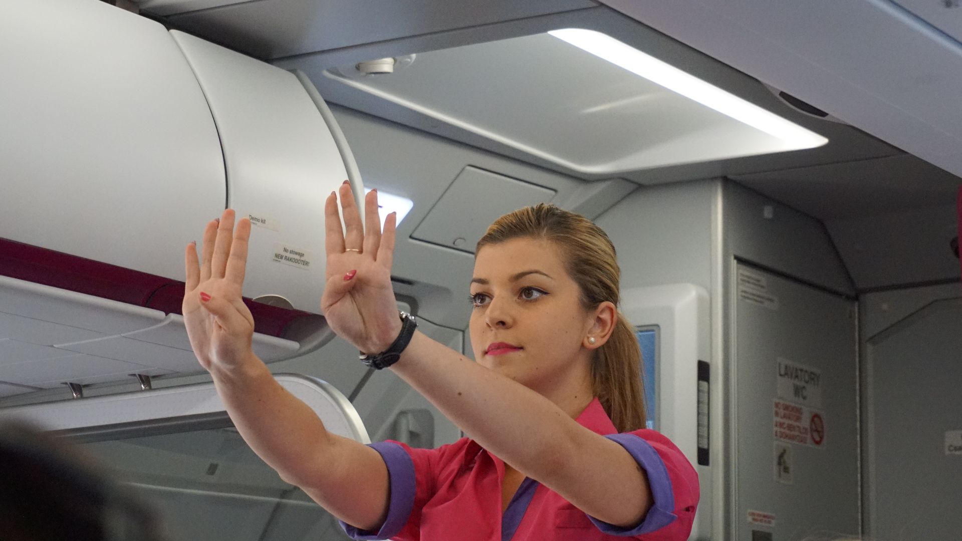 File:Female flight attendant performing a pre-flight safety demonstration.jpg
