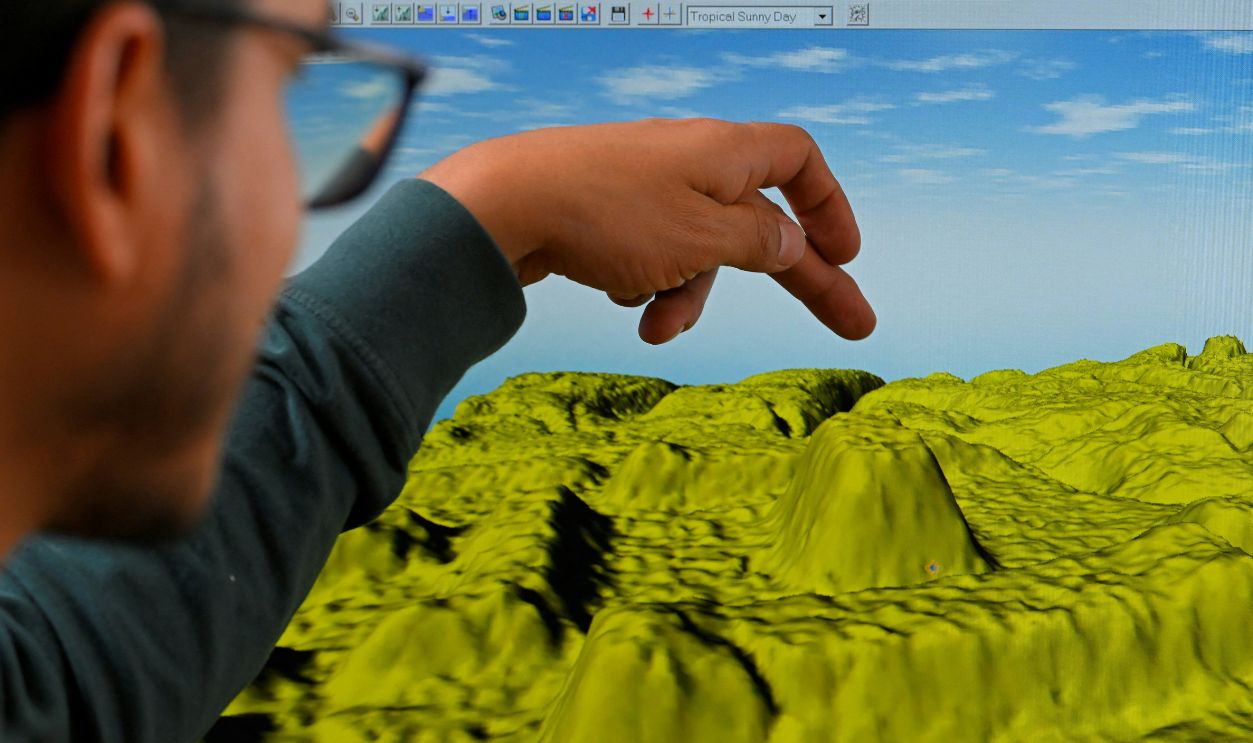 Geomatics analyst at the Institute of Cultural Heritage, Leonardo Auz, shows a digital representation of the relief of an area near the Upano River in the Ecuadorian Amazon, where there would be monumental archaeological remains, at the institute's headquarters in Quito on January 31, 2024. The thickness of the forest protected them for thousands of years, but the passage of machinery and natural erosion have put at risk enormous mounds of an ancient Amazonian civilization in the Upano valley, in Ecuador, where strategies for the conservation of a 