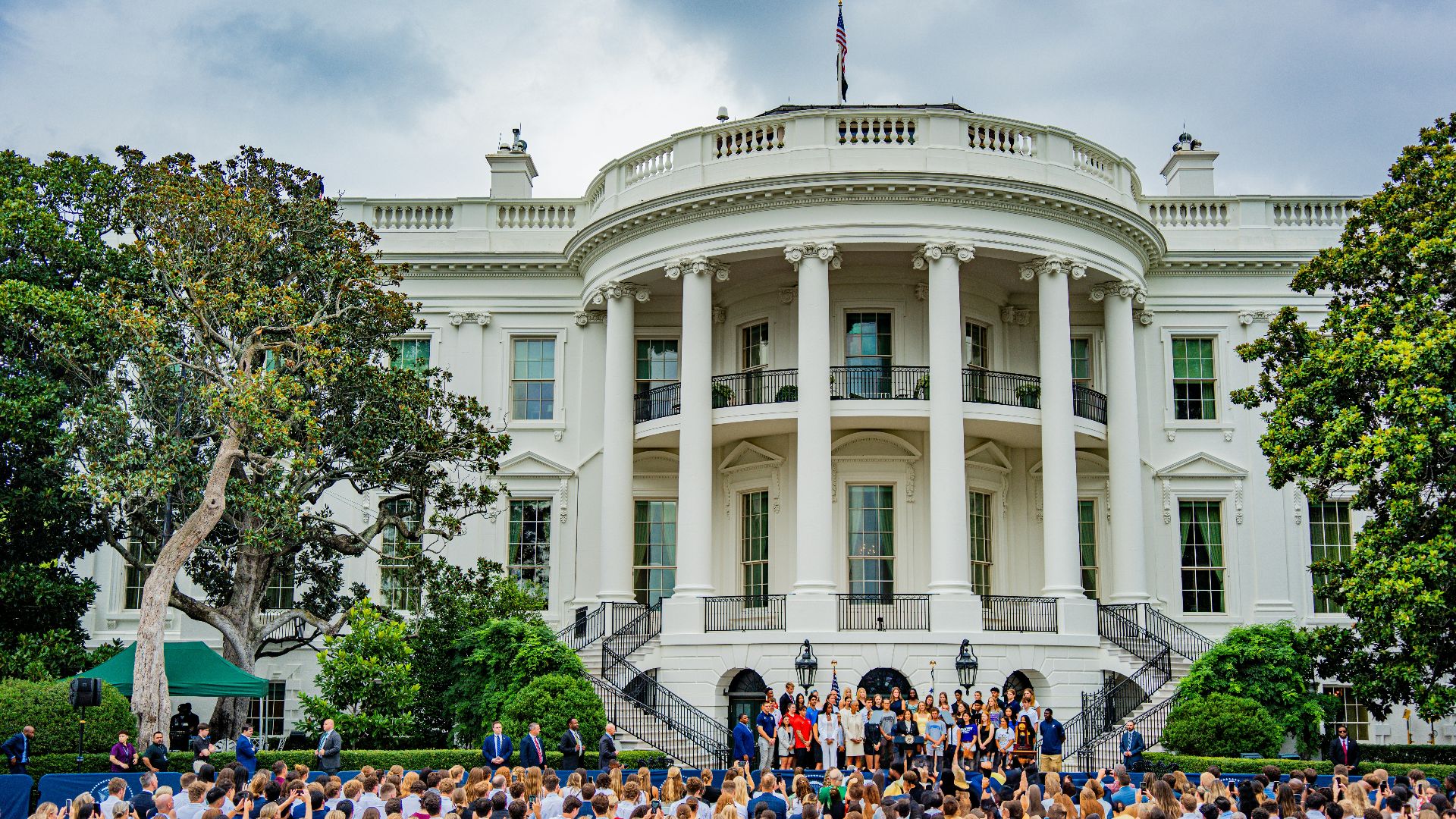 A large group of people standing in front of a white building