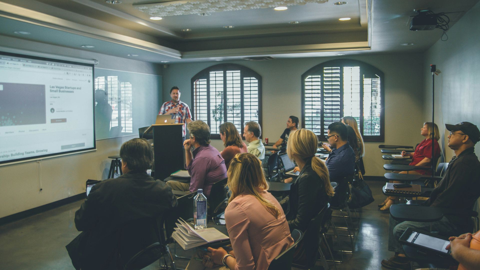 a group of people in a room with a projector screen