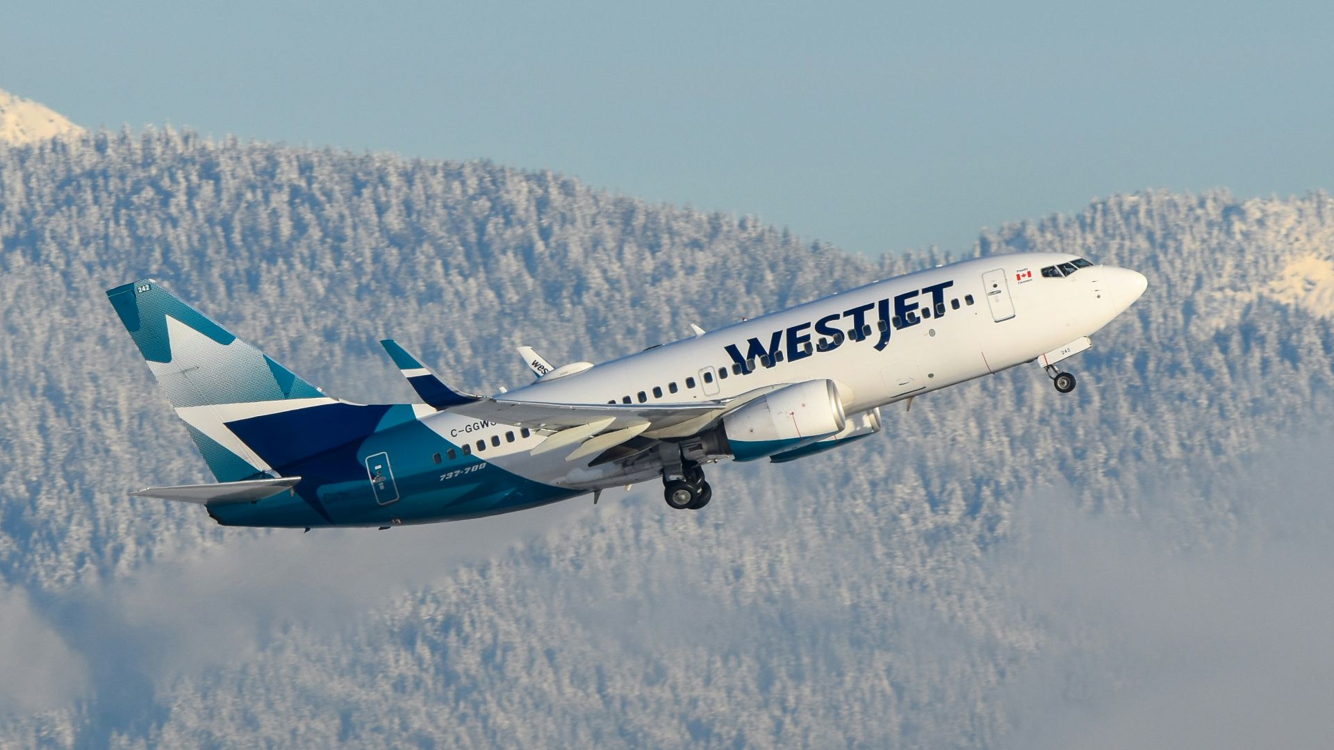 A large passenger jet flying over a mountain range
