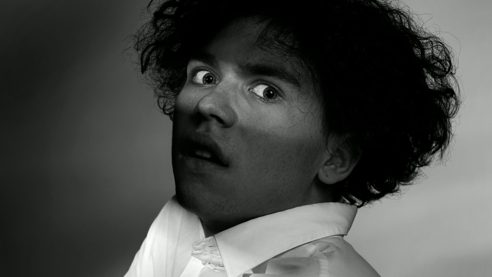 a black and white photo of a man with his arms crossed