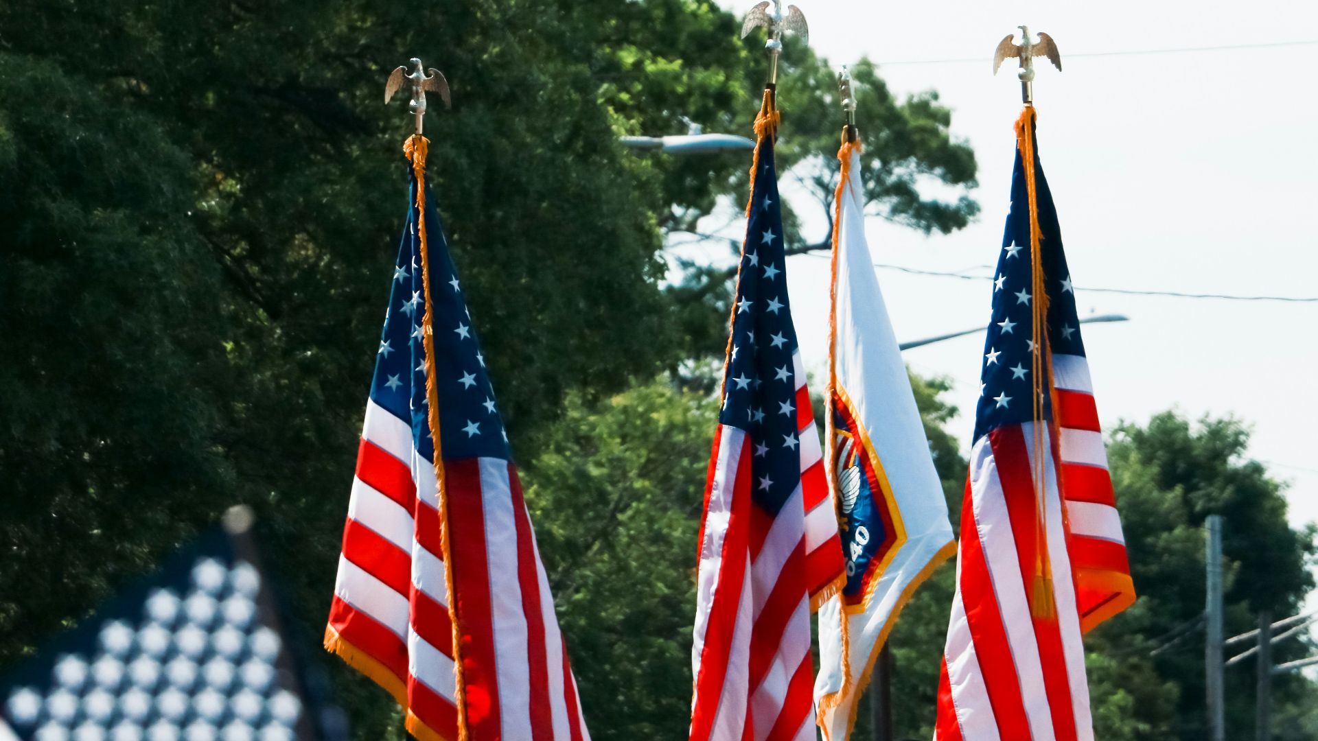 a group of people walking down a street holding american flags