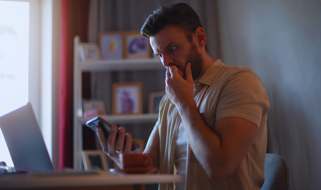 man checking phone shocked