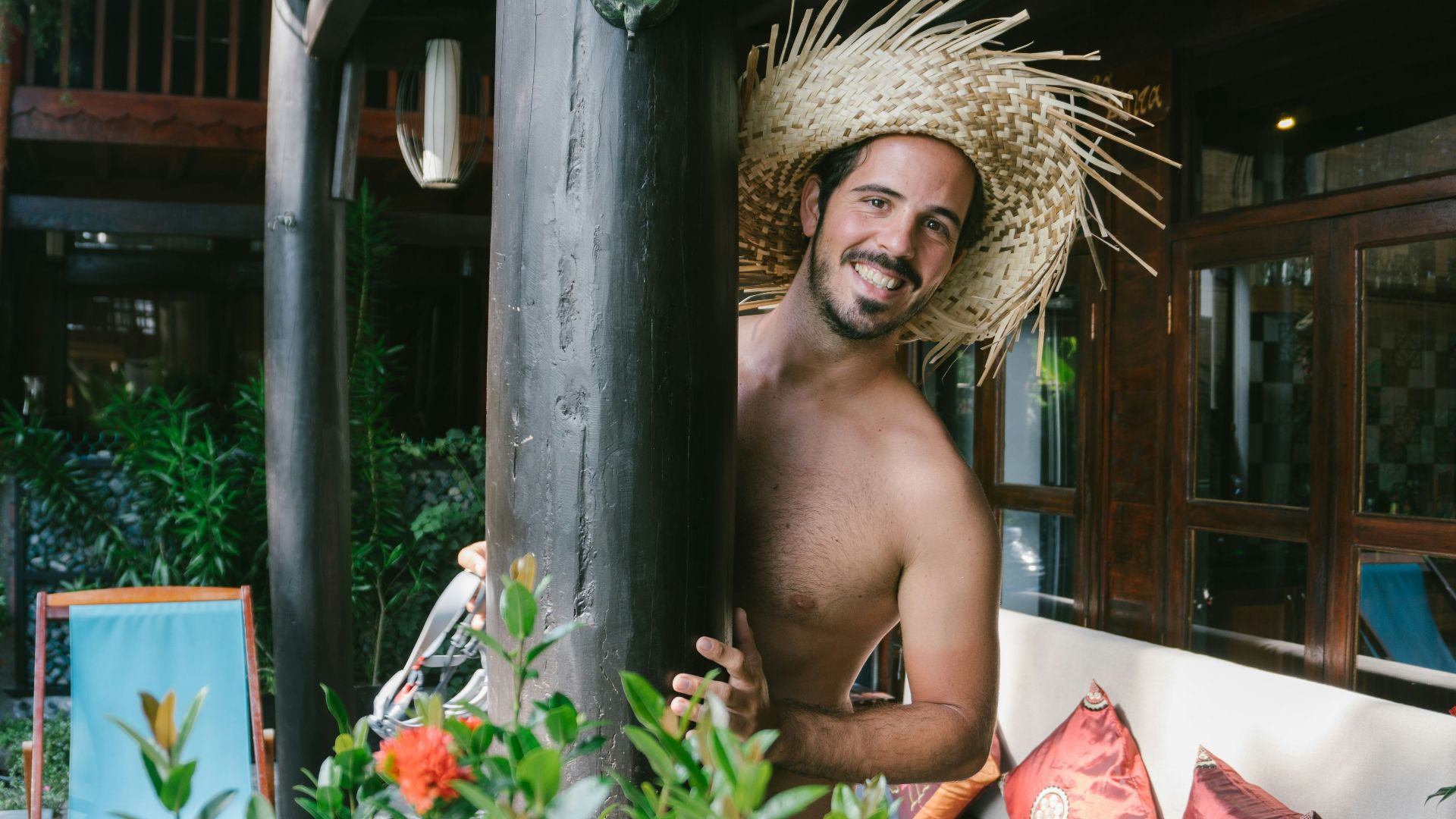 A man with a straw hat sitting on a bench