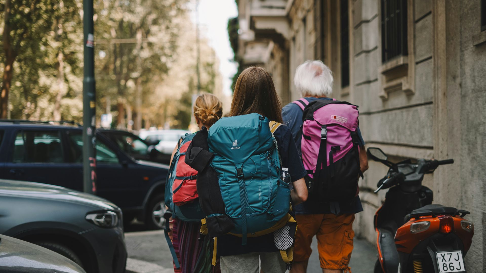 Two people with backpacks walking down the street