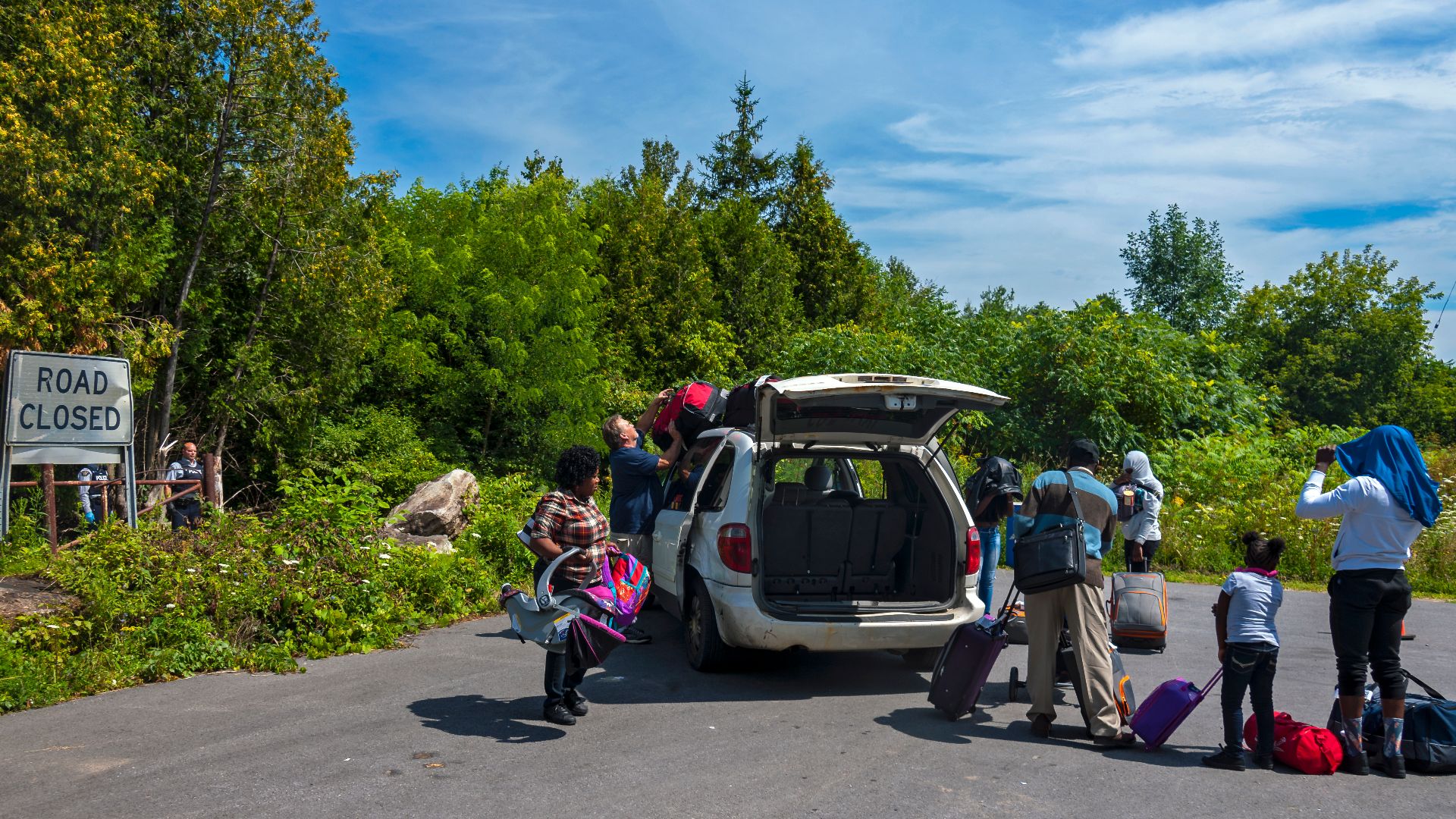 File:Family preparing to cross US-Canadian border despite signage warning them no crossing is permitted here so they can request asylum, Roxham Road, Champlain, NY.jpg