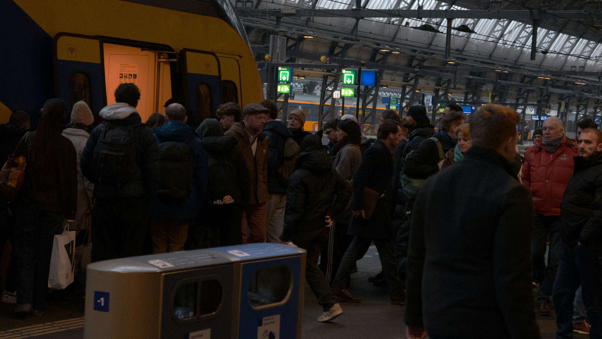 People boarding a train at a busy station.