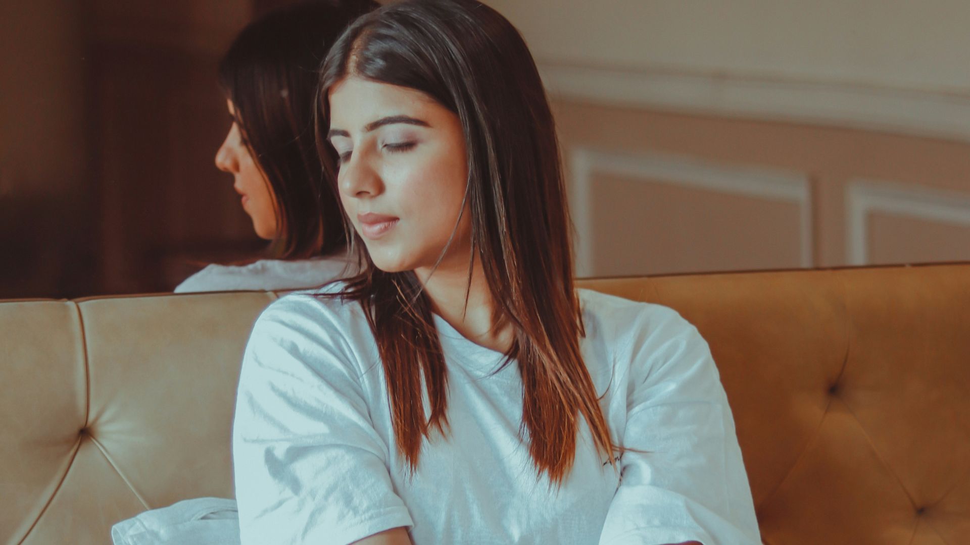 woman in white shirt sitting on bed