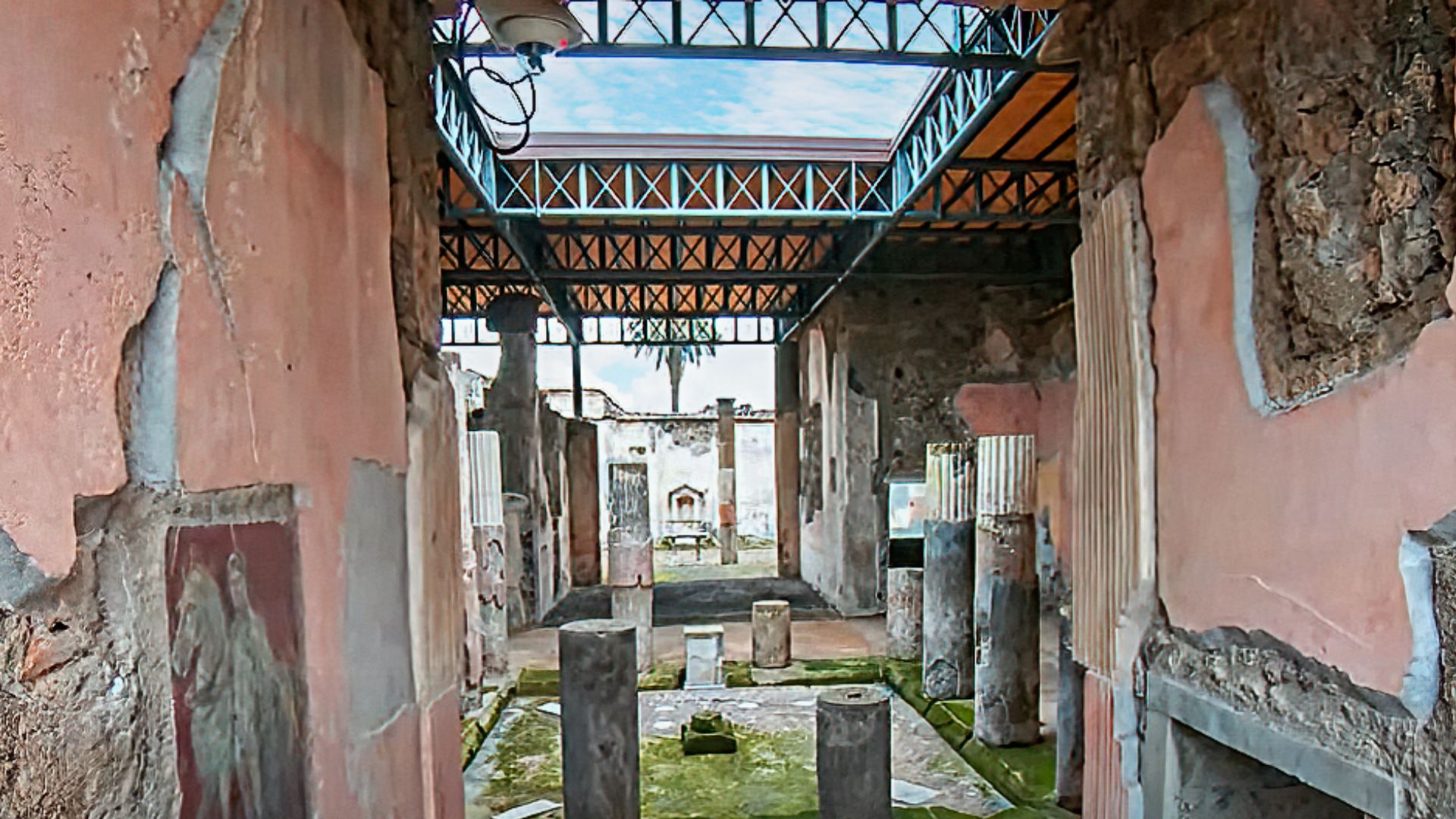 File:House of the Dioscuri excavated in 1826 entrance with view of the columned atrium with impluvium and lararium in the peristyle garden behind Pompeii Walk.jpg