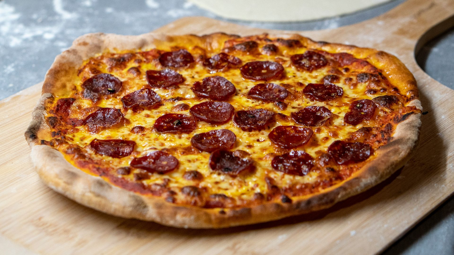 pepperoni pizza on a wooden tray