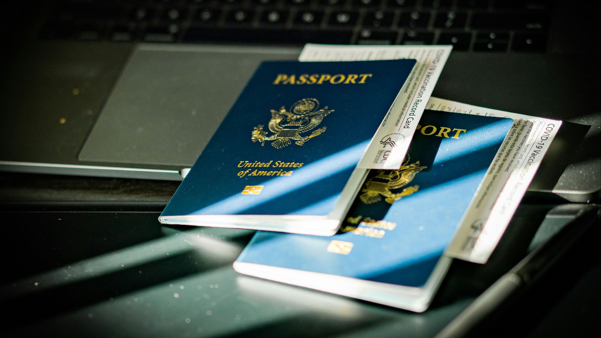 a passport sitting on top of a computer keyboard