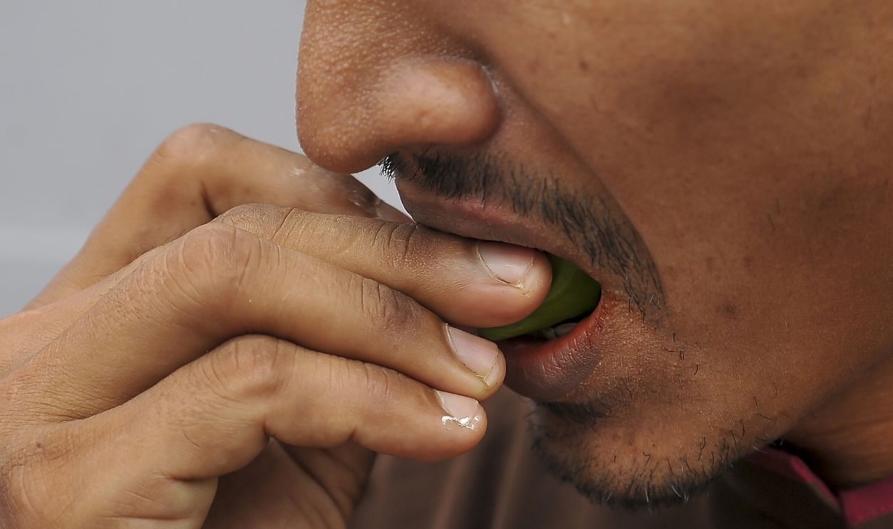 MALAYSIA, 1 September 2017 -MALAYSIA, 1 September 2017 - Rohingya man eating a betel leaf in Kuala Lumpur. (selective focusing)