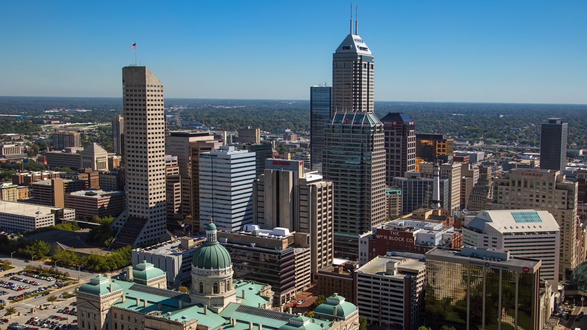 Aerial looking east northeast across downtown Indianapolis. The Indiana Statehouse is visible in the foreground.