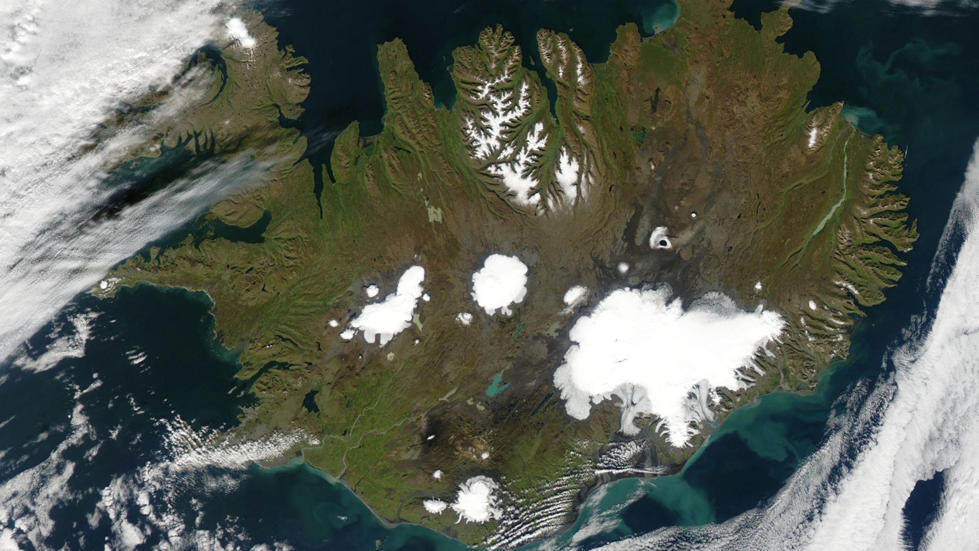 Summer is winding to a close on September 9, 2002, but even Iceland is still showing some summer color, its perimeter tinged with green, while its large permanent ice caps stand out brightly against the volcanic rock surrounding them. The largest ice cap,