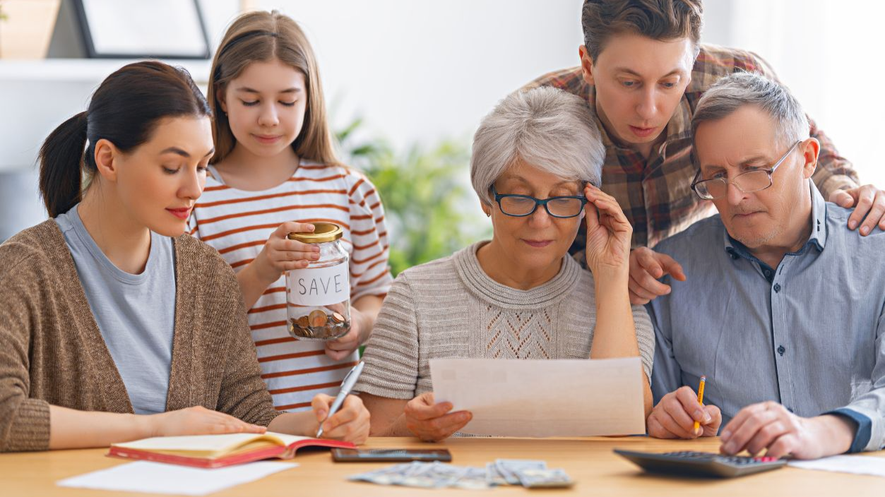 Shutterstock-1940907469, Family are sitting at a desk with a paper receipt and calculating expenses, managing budget.