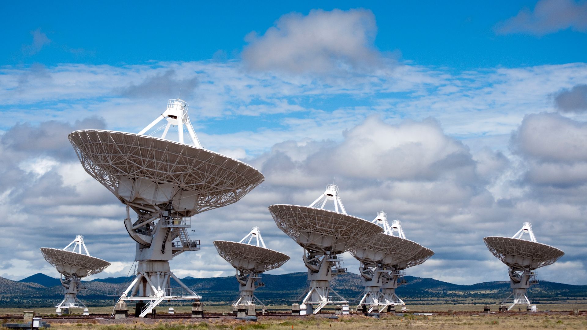 A few of the dish antennas of the Very Large Array a radio telescope  located in Socorro, New Mexico, USA.  Completed in 1980, it consists of 27 large 25 meter diameter parabolic antennas arranged in a Y shape, mounted on railroad tracks (visible at botto
