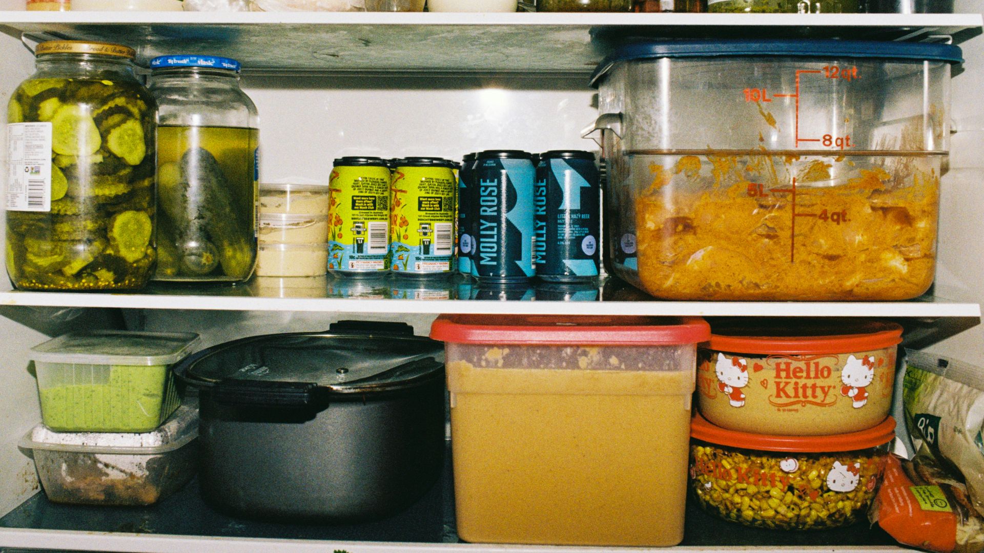 Refrigerator shelves packed with jars, cans, and food containers