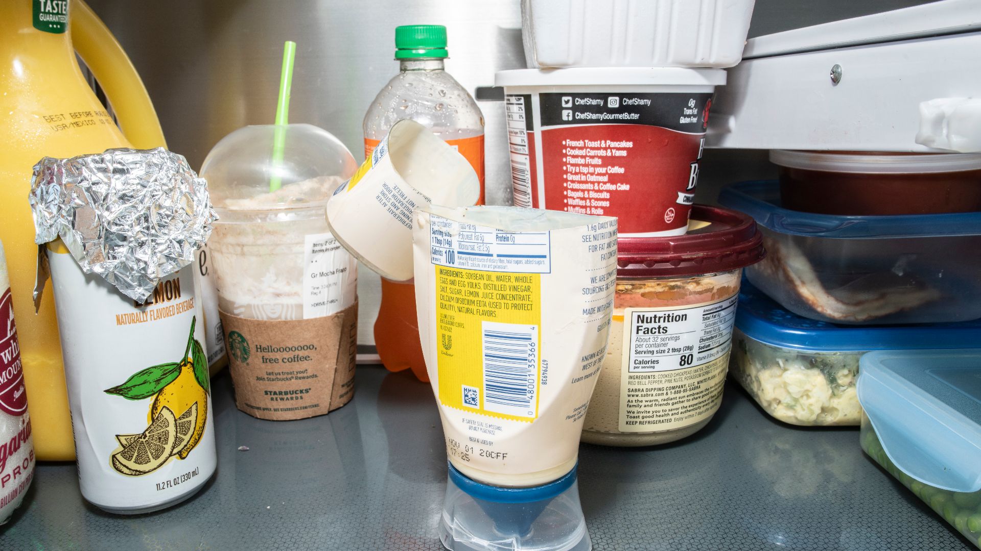 Refrigerator with some poorly stored and placed items for food safety and contributes to food waste, on June 8, 2020, in San Antonio, TX. 
The refrigerator shows recommended and unrecommended storage practices. It is always recommended to keep your refrig