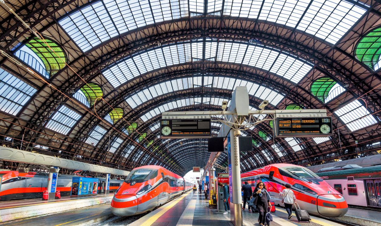 Modern high-speed trains at railway Milan Central Station, Italy, Europe. Scenery of industrial landmark of Milan. Theme of transport, tourism, railroad and travel across Italy. Milano - May 17, 2017
