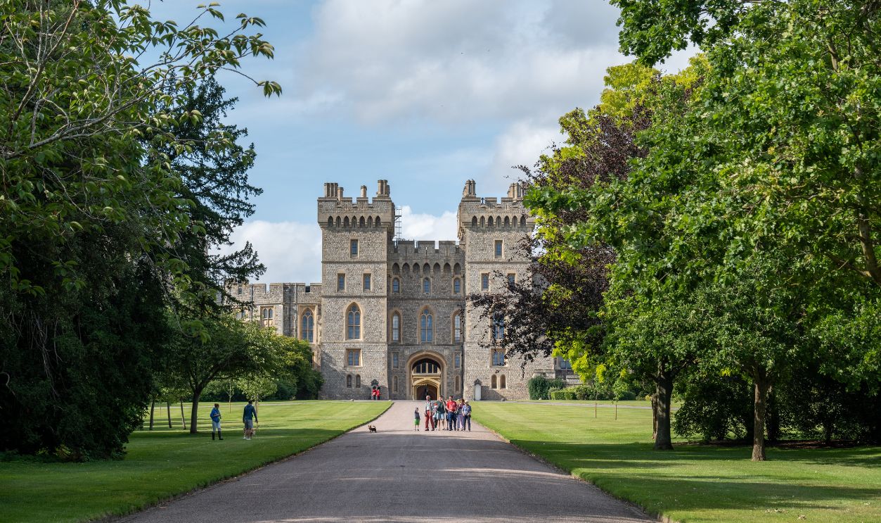 Charming scene of Windsor Castle surrounded by lush greenery and visitors