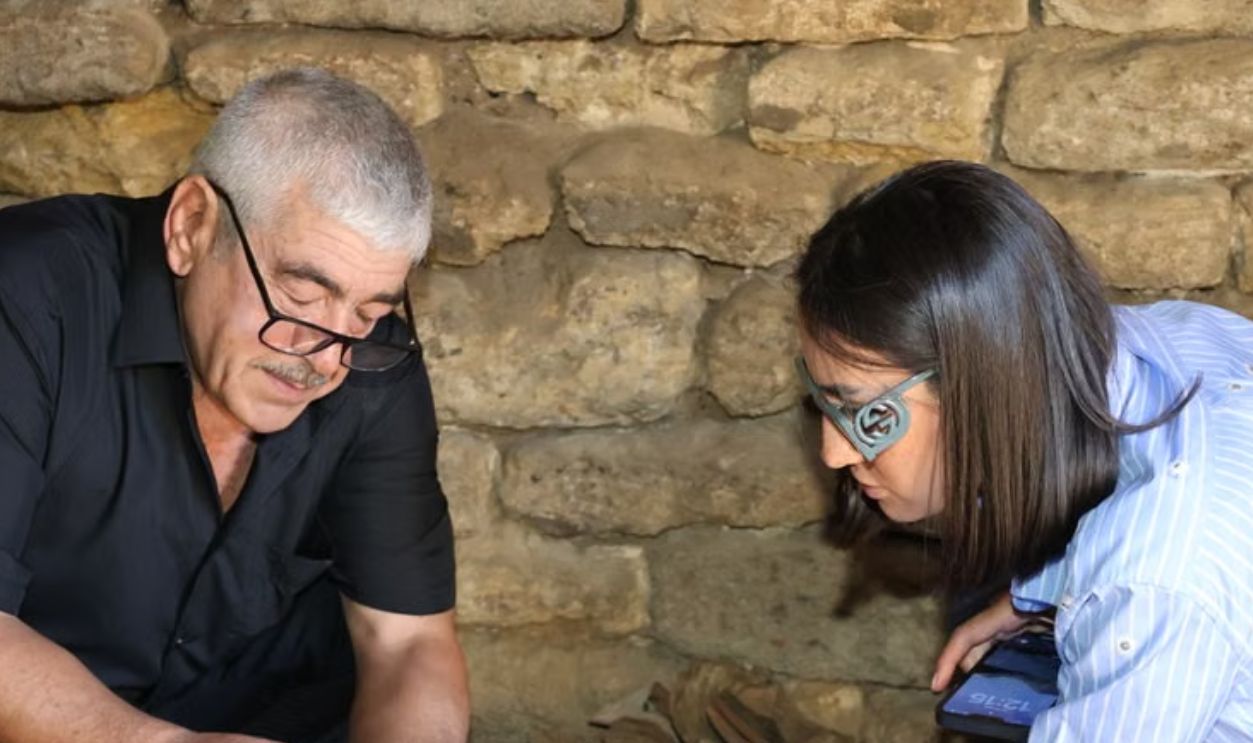 Researchers study ancient artifacts in a historic stone setting, uncovering history.